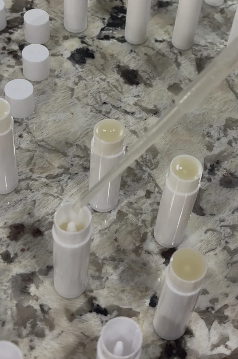 Carefully filling small batches of Comfort & Kind lip balm by hand